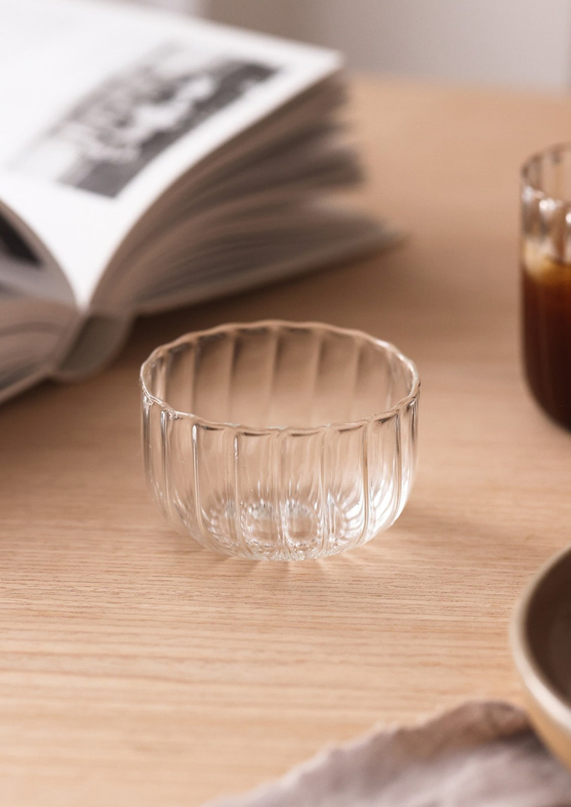 A small clear glass bowl with fluted texture.