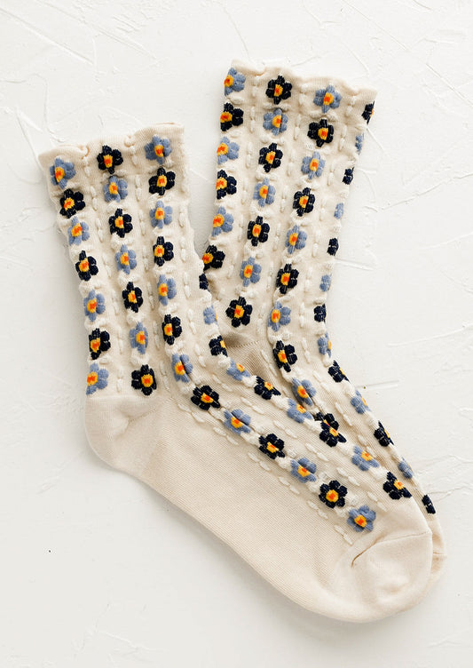 A pair of ivory socks with blue flowers.