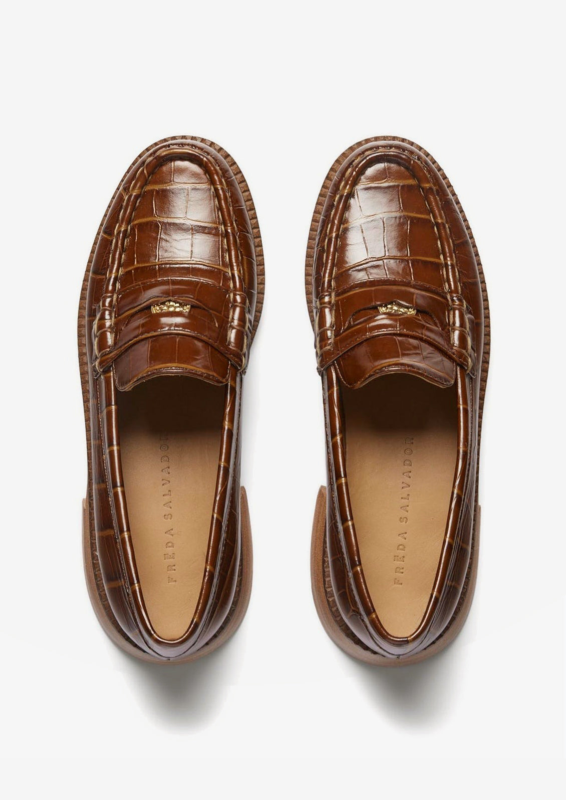 A pair of penny loafers in brown croc embossed leather.