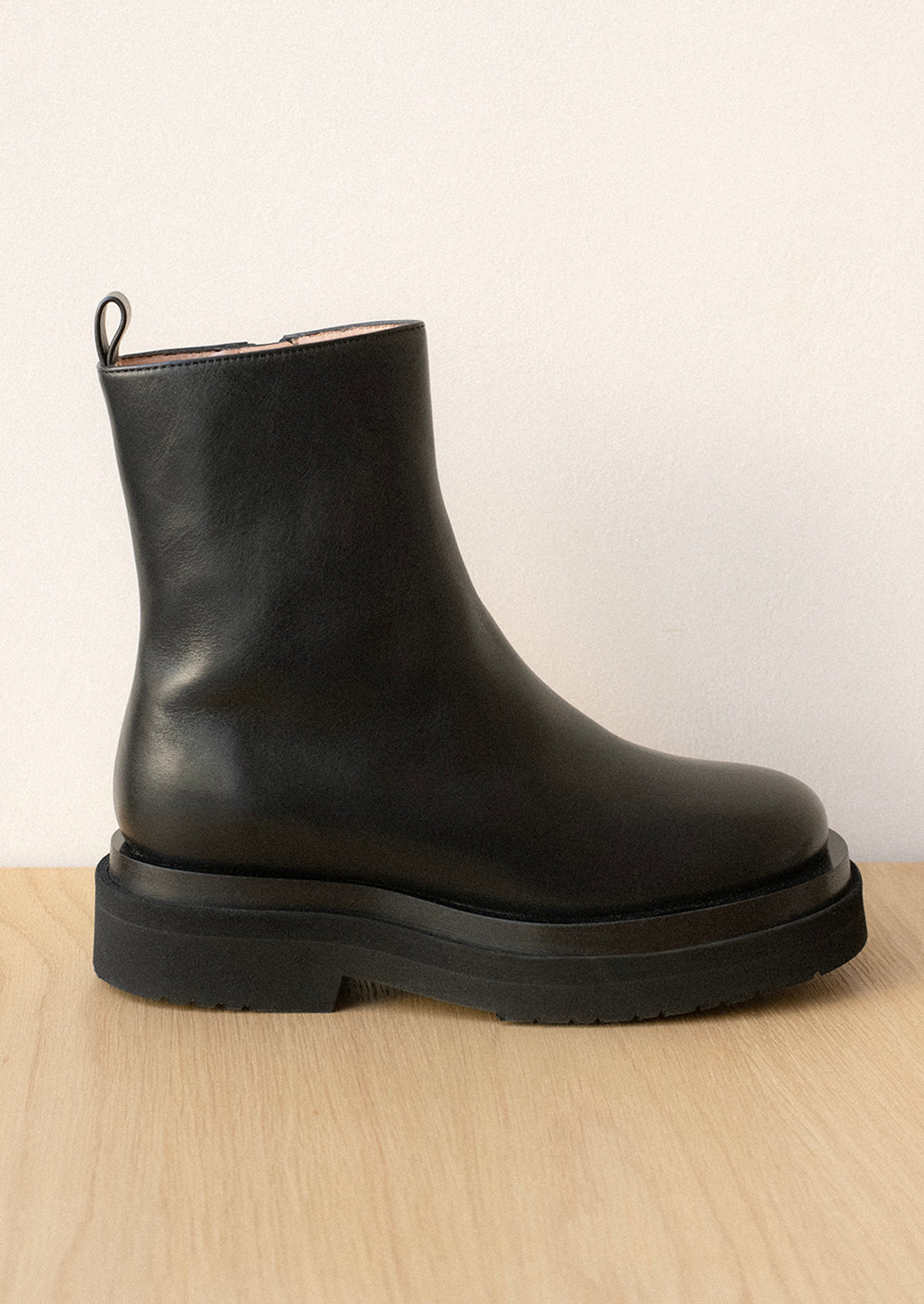 A pair of black leather boots with thick chunky sole.