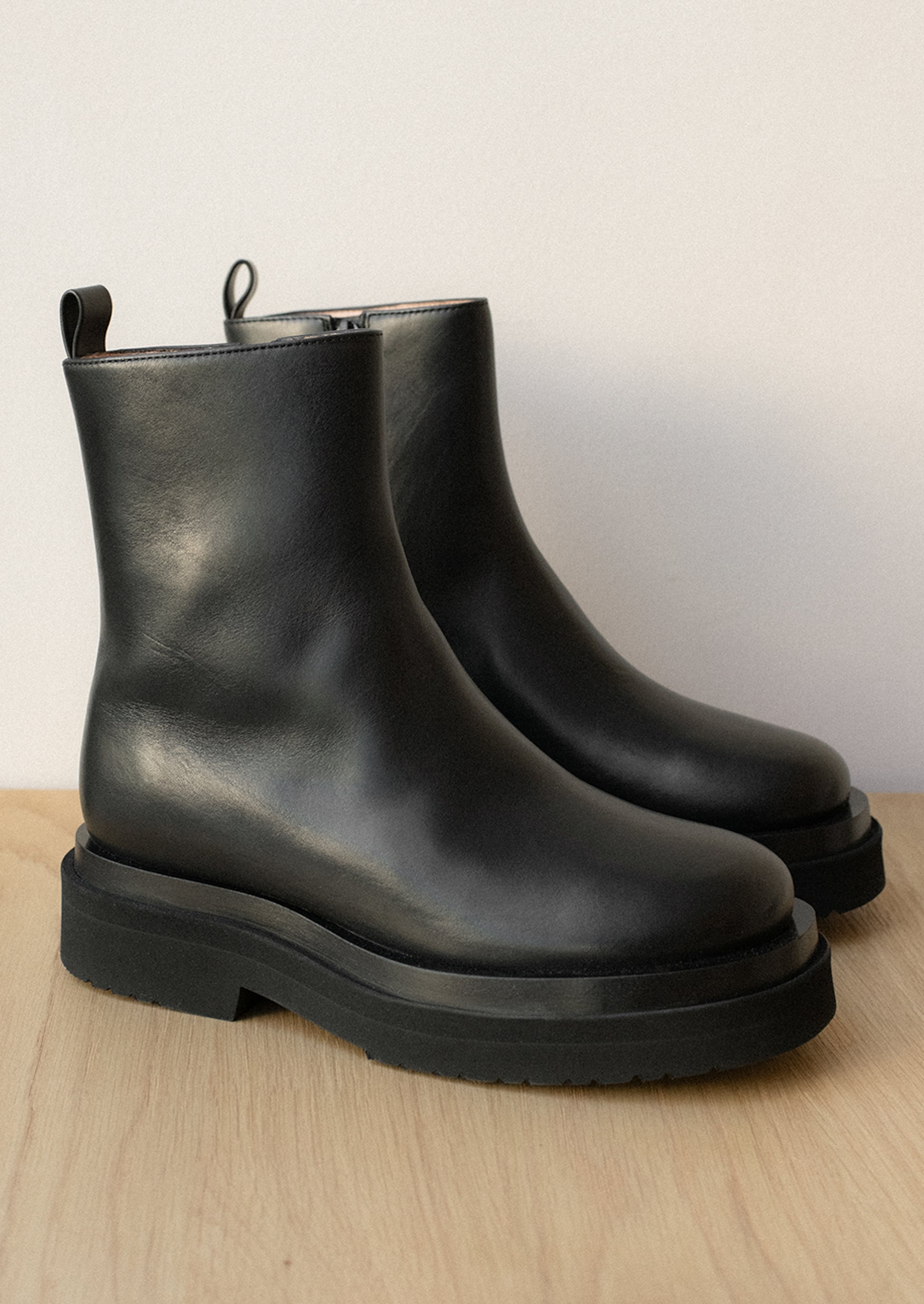 A pair of black leather boots with thick chunky sole.