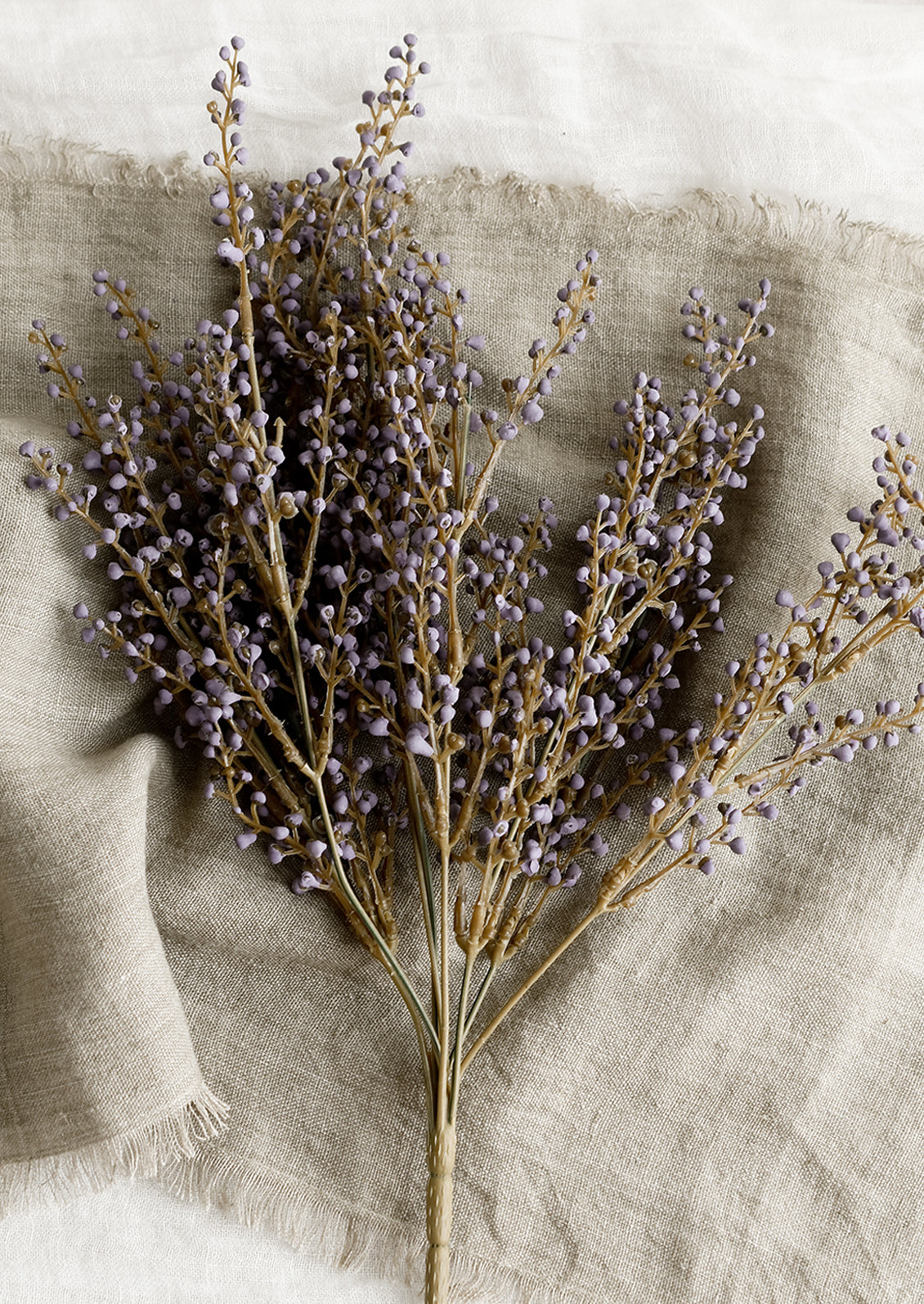 An artificial floral stem with purple privet berry.