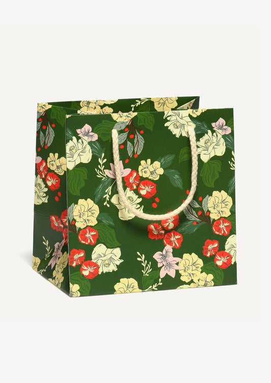 A small printed gift bag in green with white and red floral print.