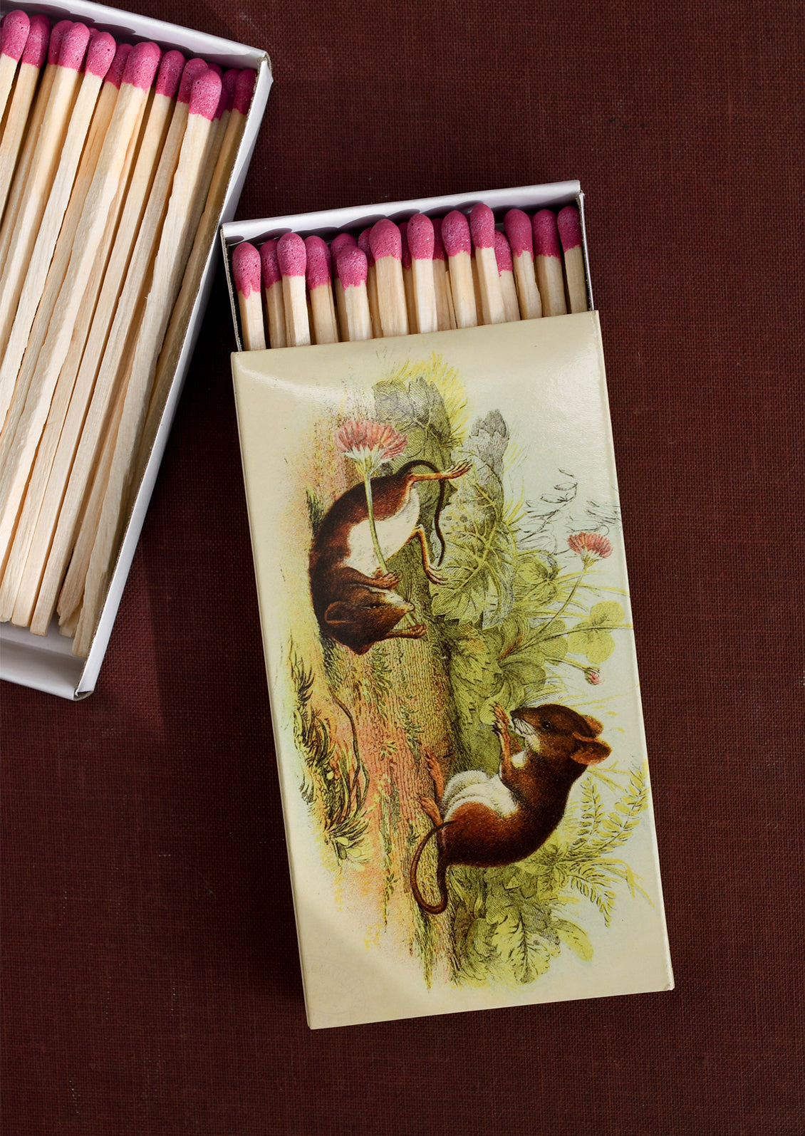 A printed, sliding matchbox with vintage style illustration of mice with flowers.