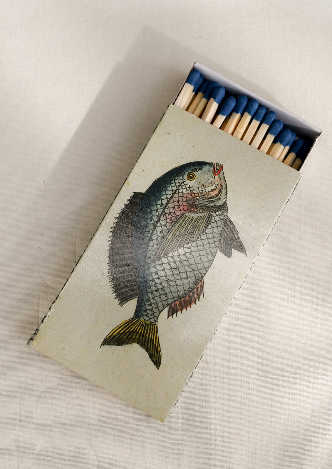 A printed sliding matchbox with fish pattern.