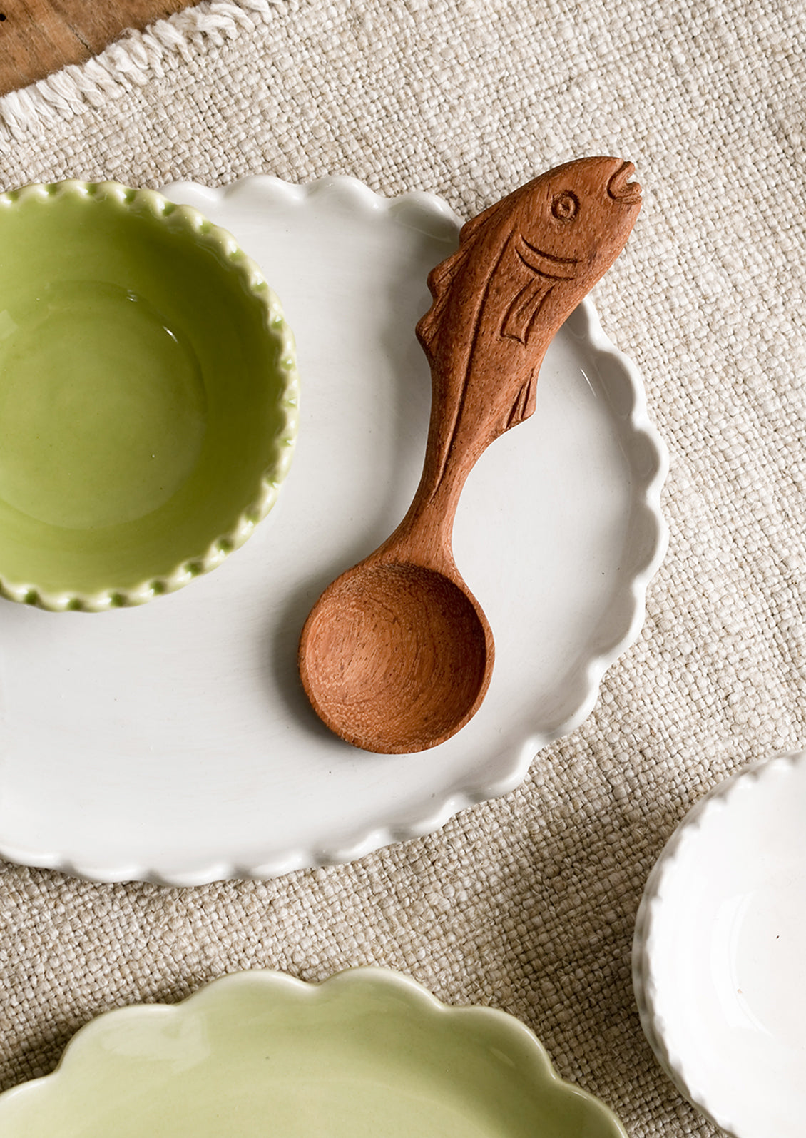 A wooden spoon with a handle carved in the shape of a fish.