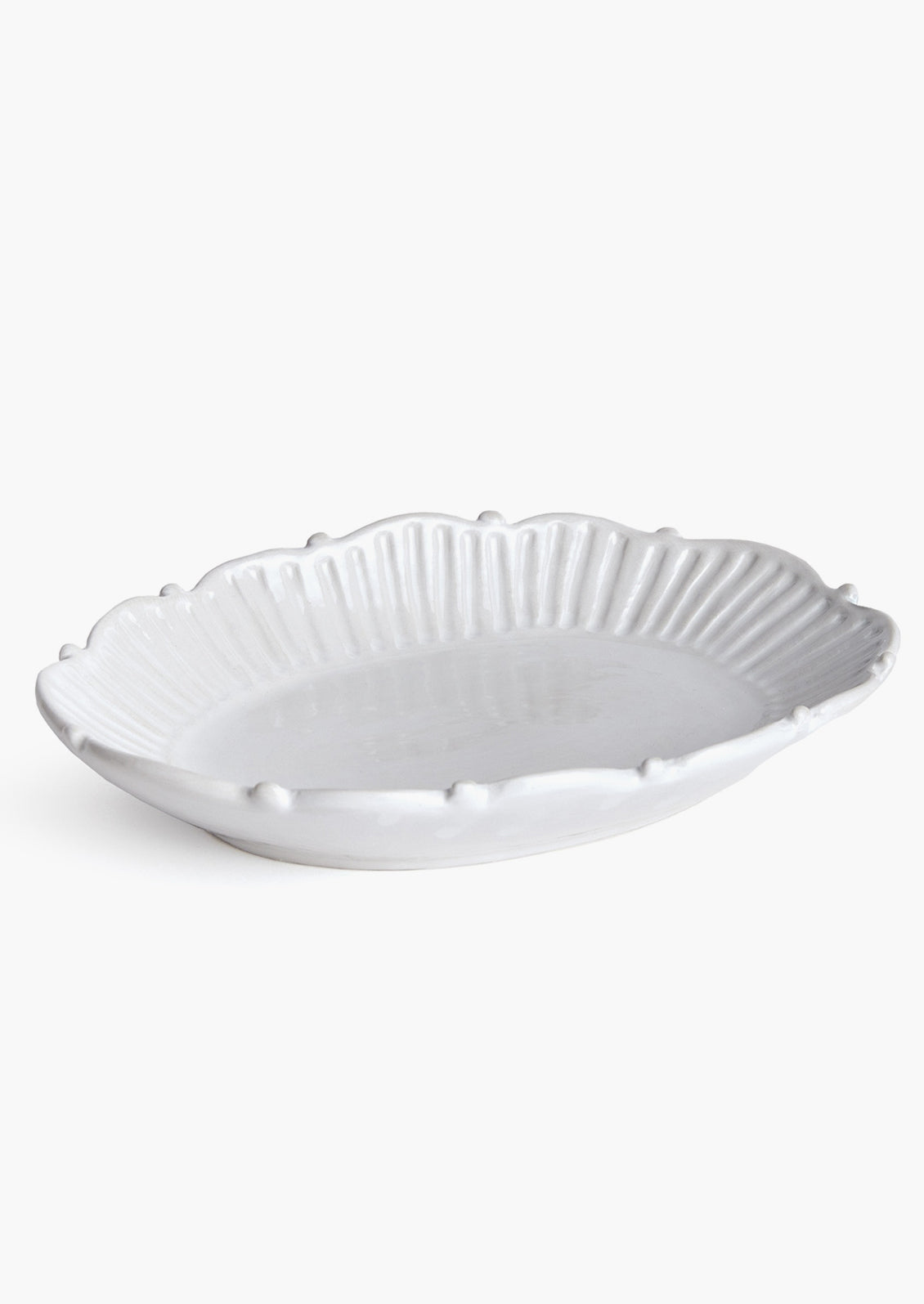 An oval shaped tray with ruffled and pleated border with ball detail around edges.