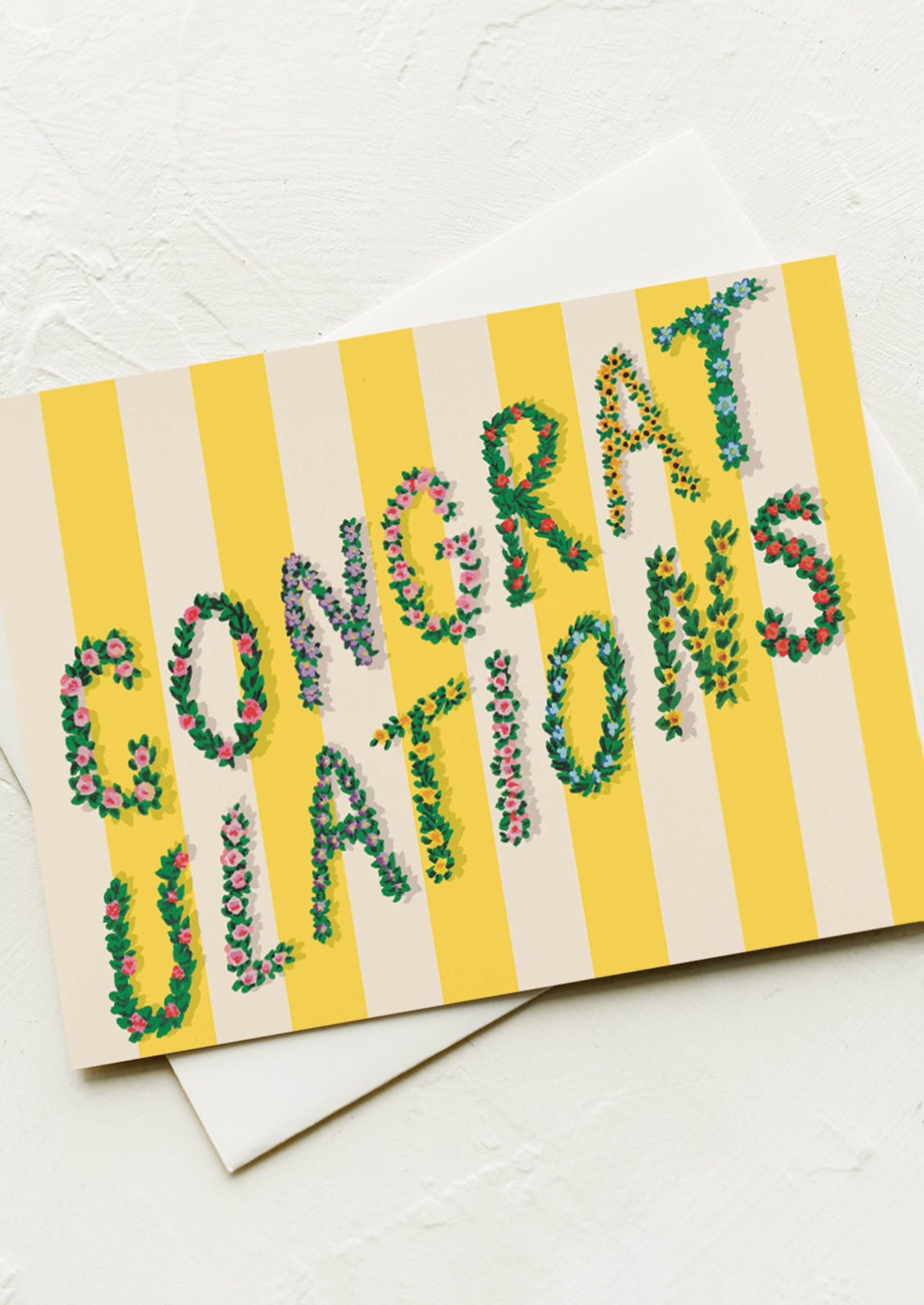 A yellow stripe greeting card with flowery letters reading "Congratulations".