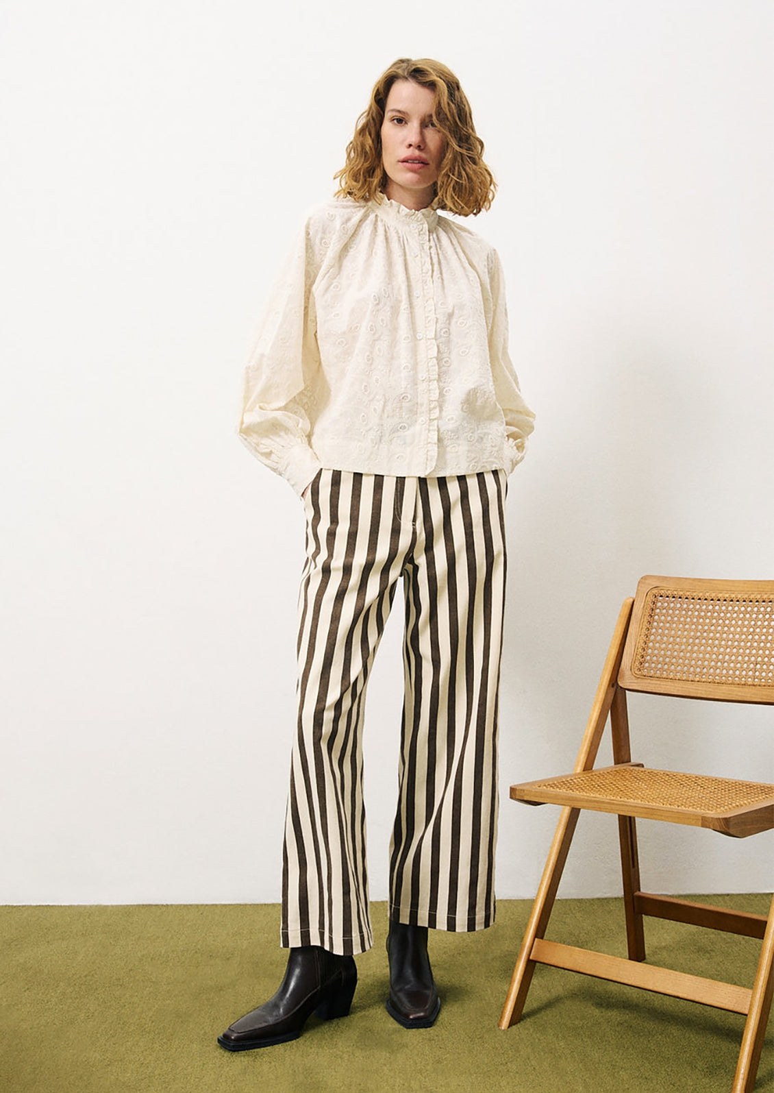 A woman wearing a cream cotton blouse with tonal paisley embroidery.