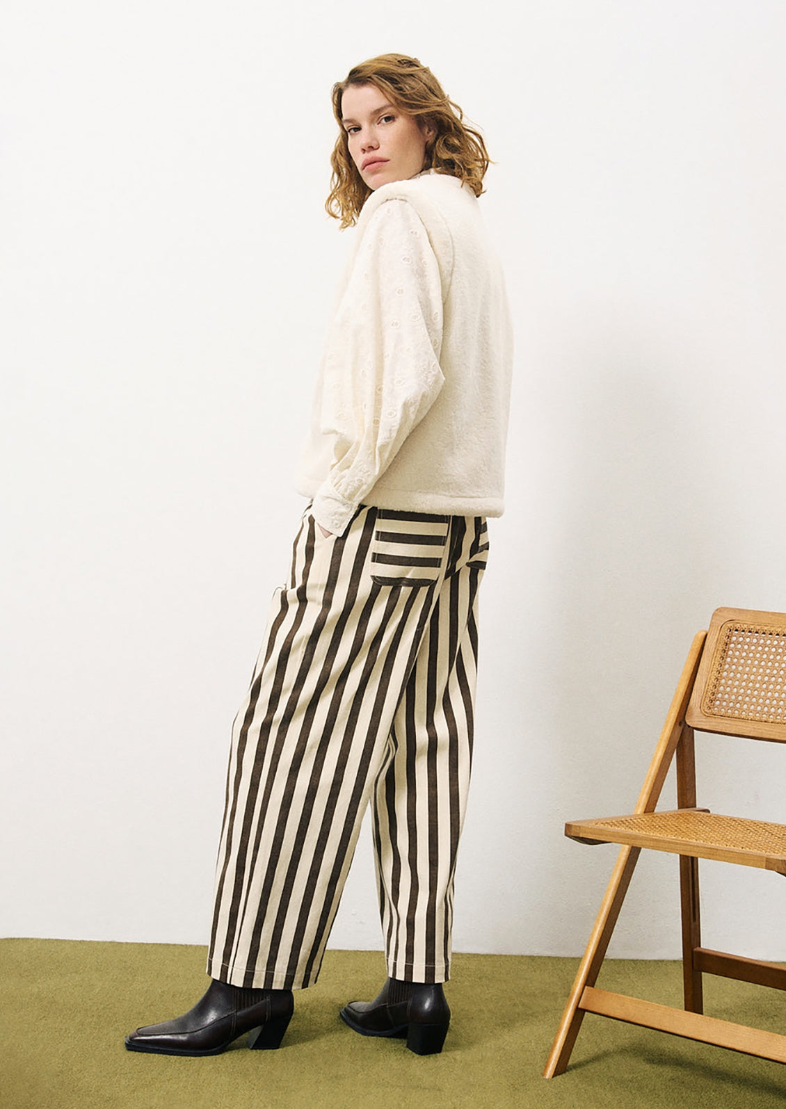 A woman wearing a cream cotton blouse with tonal paisley embroidery.