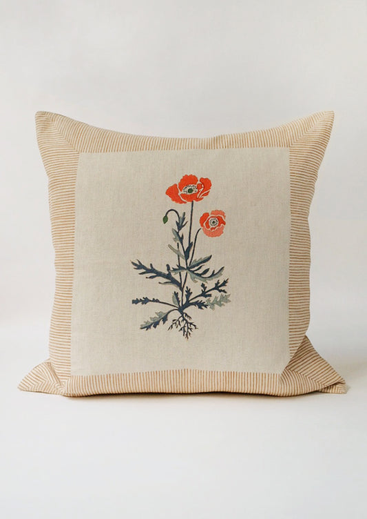 A square block printed throw pillow with framed poppy design.