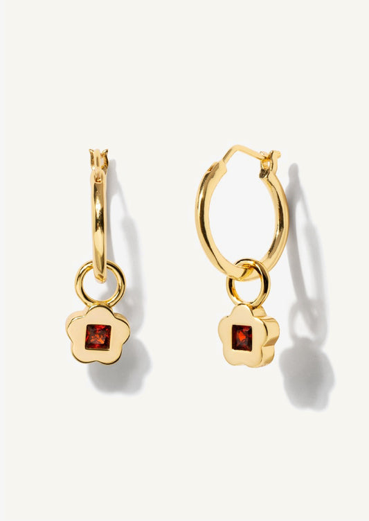 A pair of gold hoop earrings with garnet flower charm.