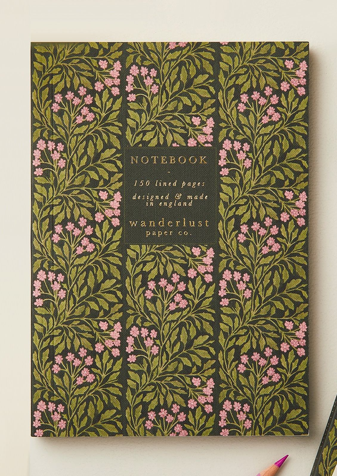 A green and pink floral print notebook.