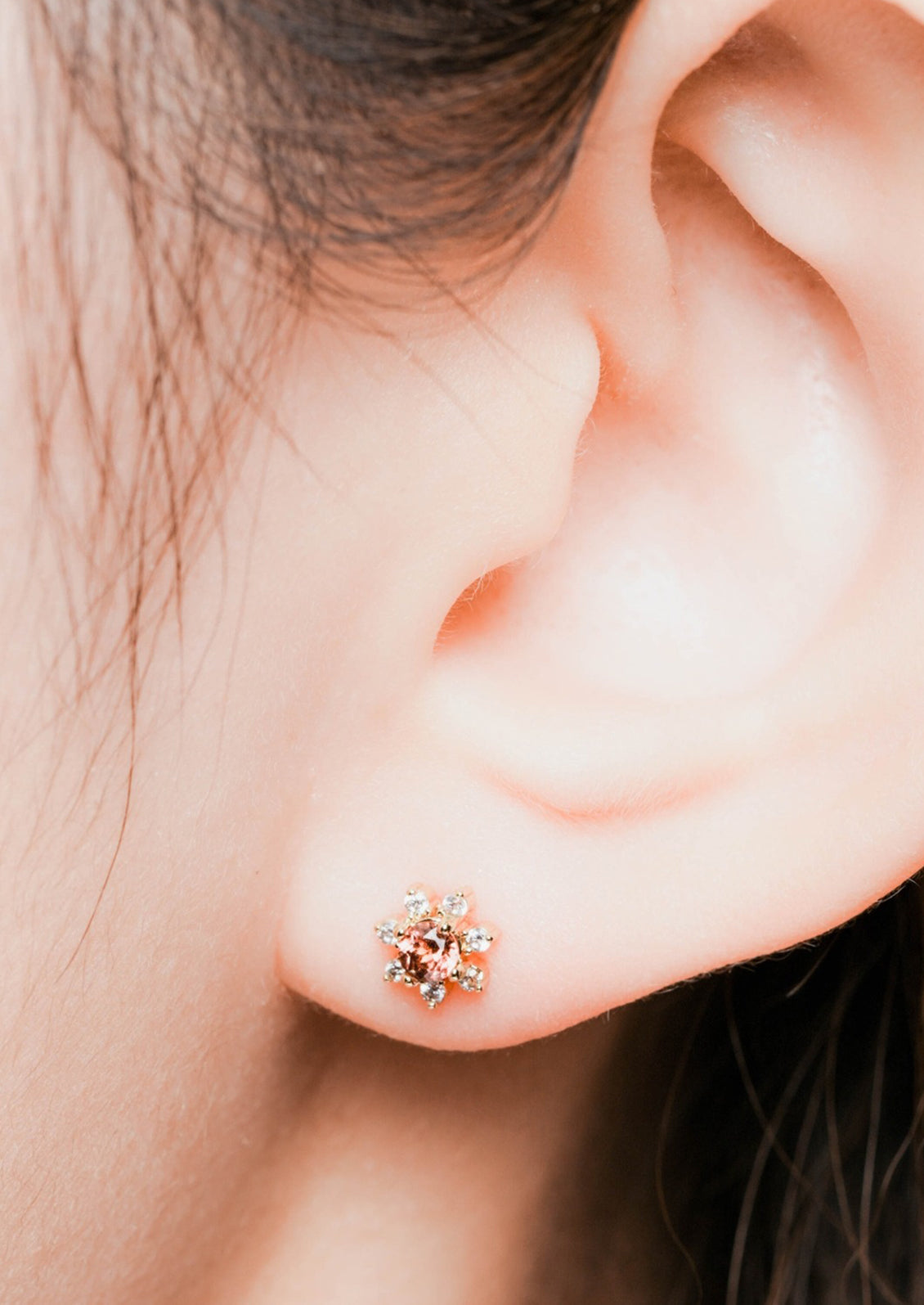 A pair of flower shaped studs with gemstone and crystal in red.