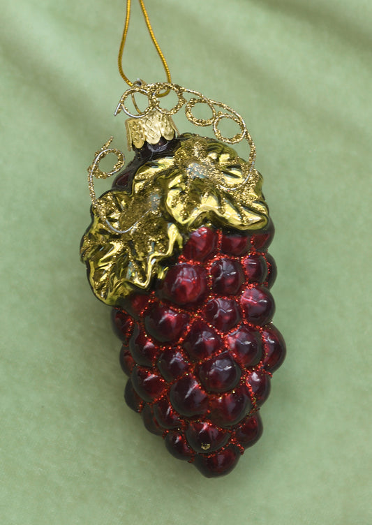 A glass ornament of a bunch of red grapes.