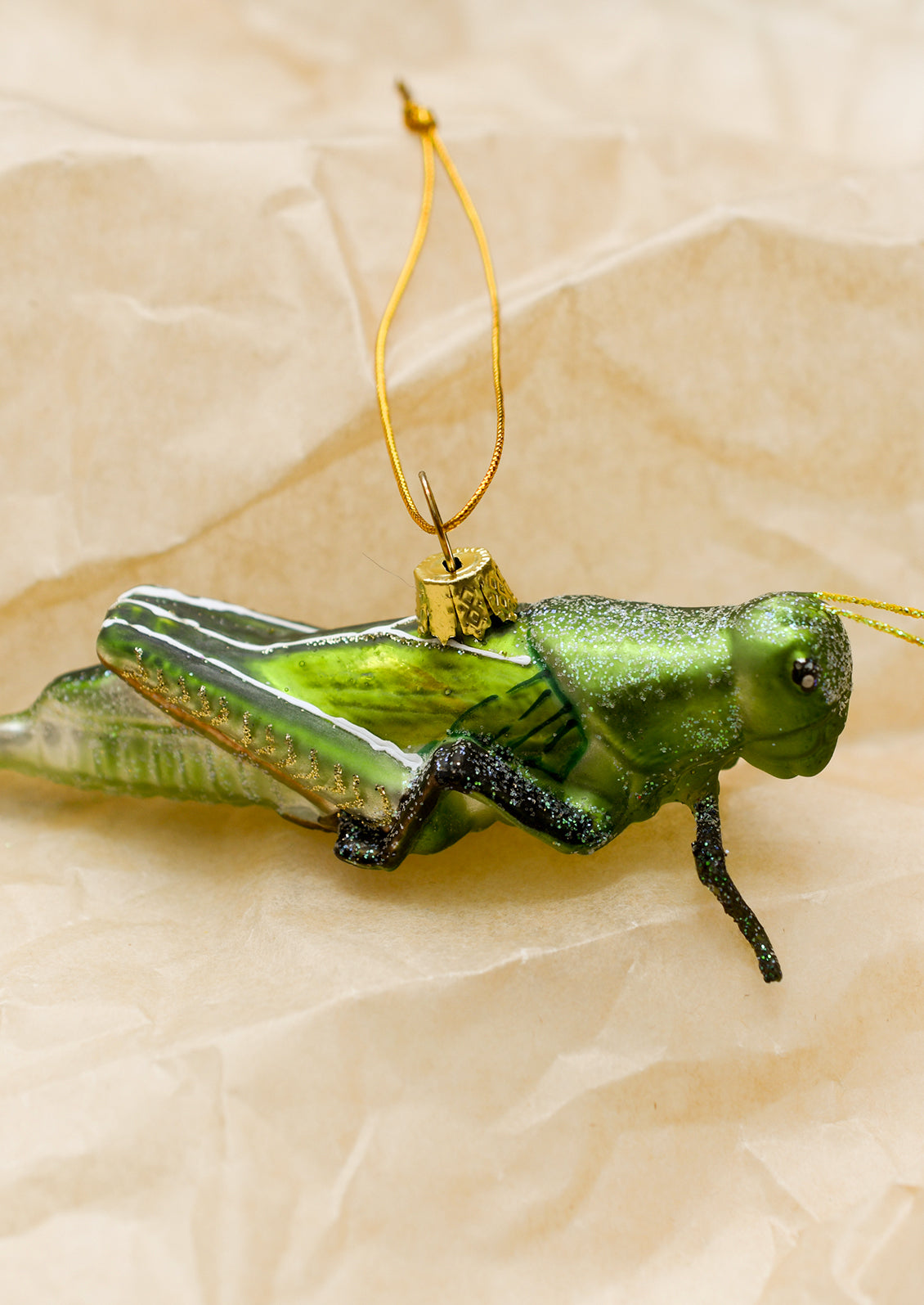 A glass ornament of green grasshopper.