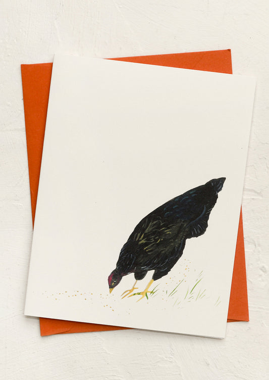 A card with illustration of black chicken grazing in grass.