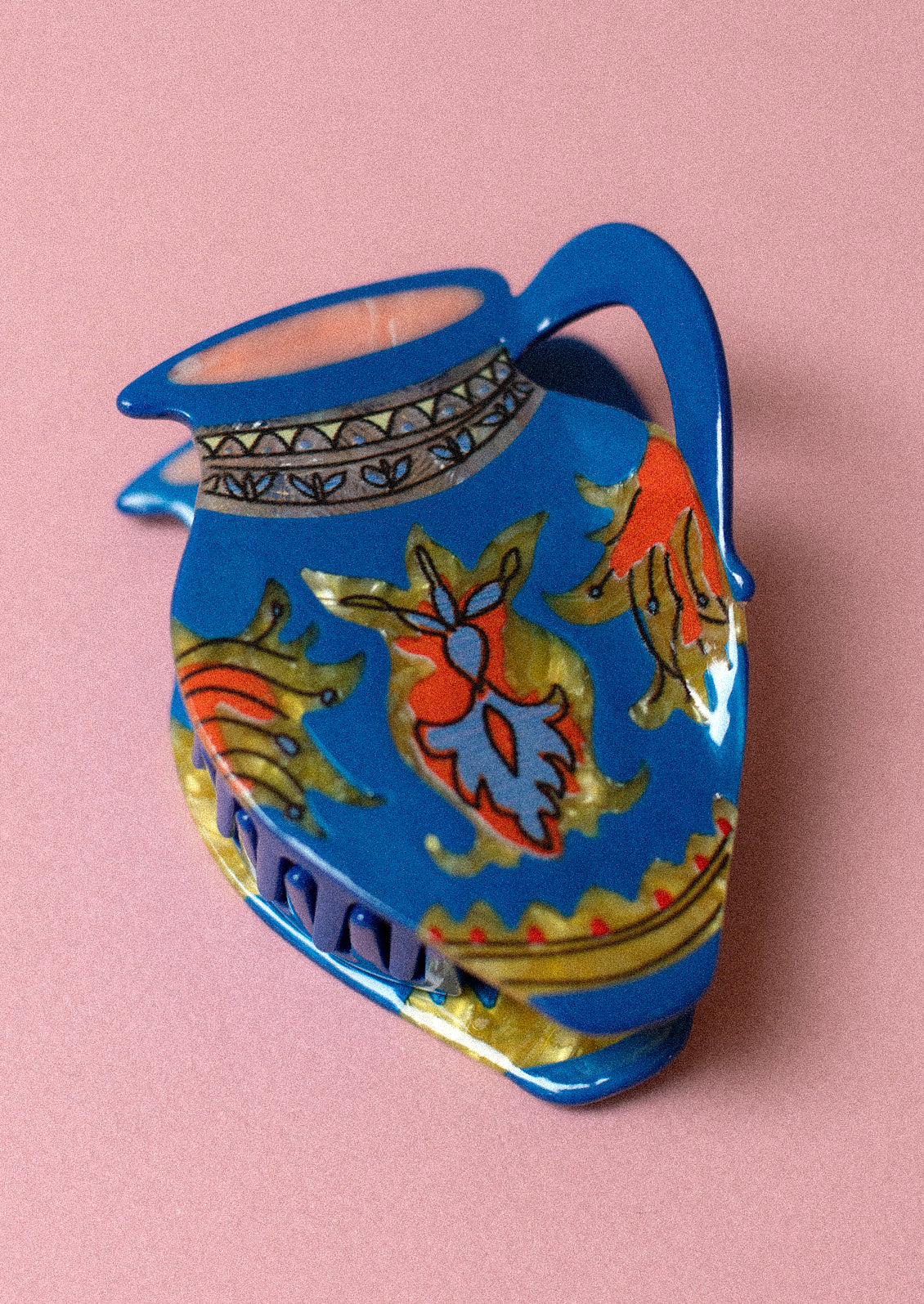 A blue hair claw in shape of an antique vase with ornate detailing.