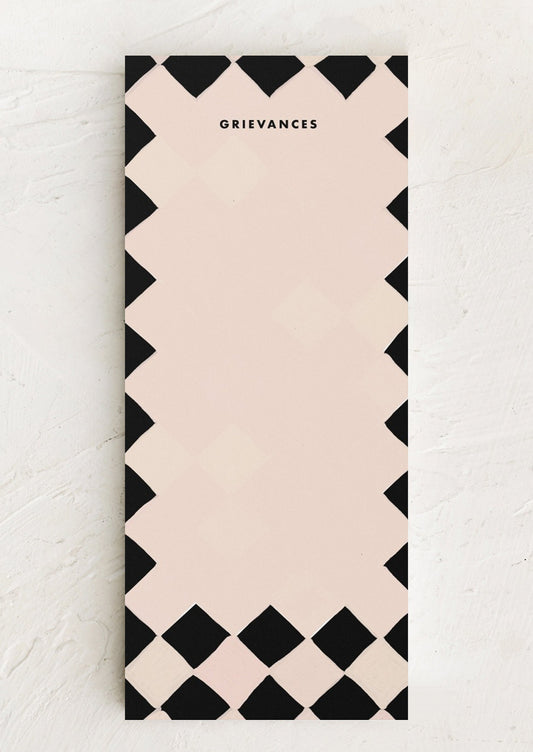 A black and white argyle print notepad reading "Grievances" at top.