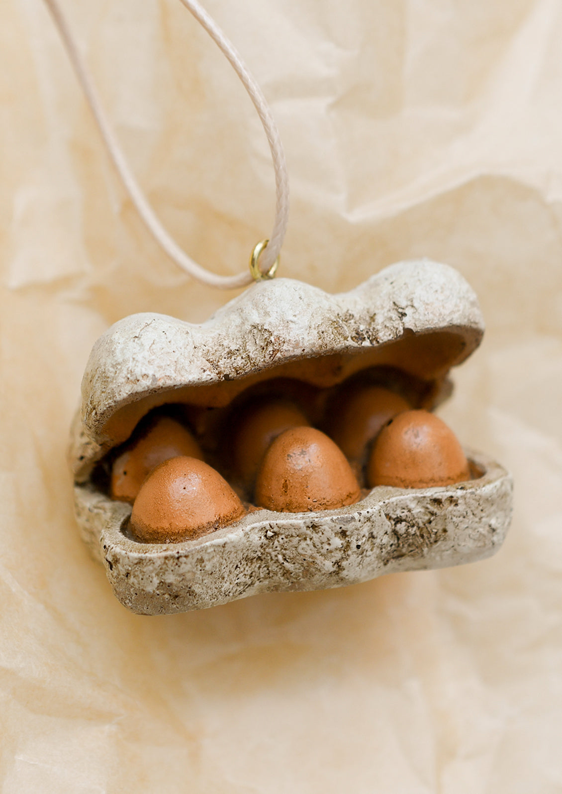 An ornament depicting a carton of a half dozen brown eggs.