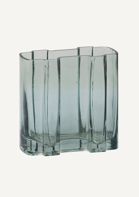 A transparent glass vase in lake blue color, rectangular shape with asymmetric form.