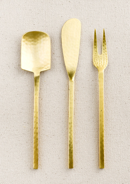 A spoon, fork and knife canape utensils in hammered gold finish.