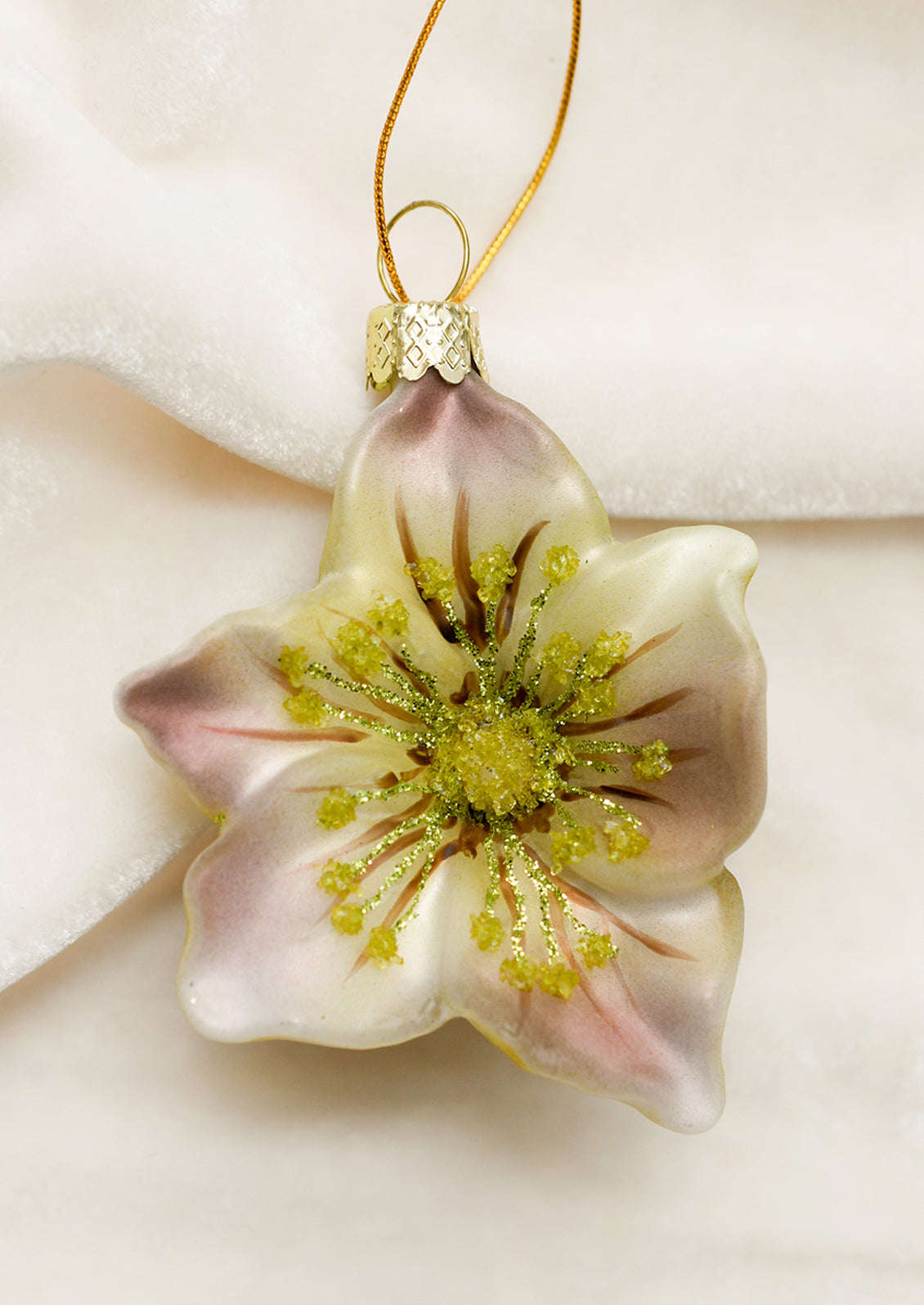 A glass ornament depicting a hellebore flower.