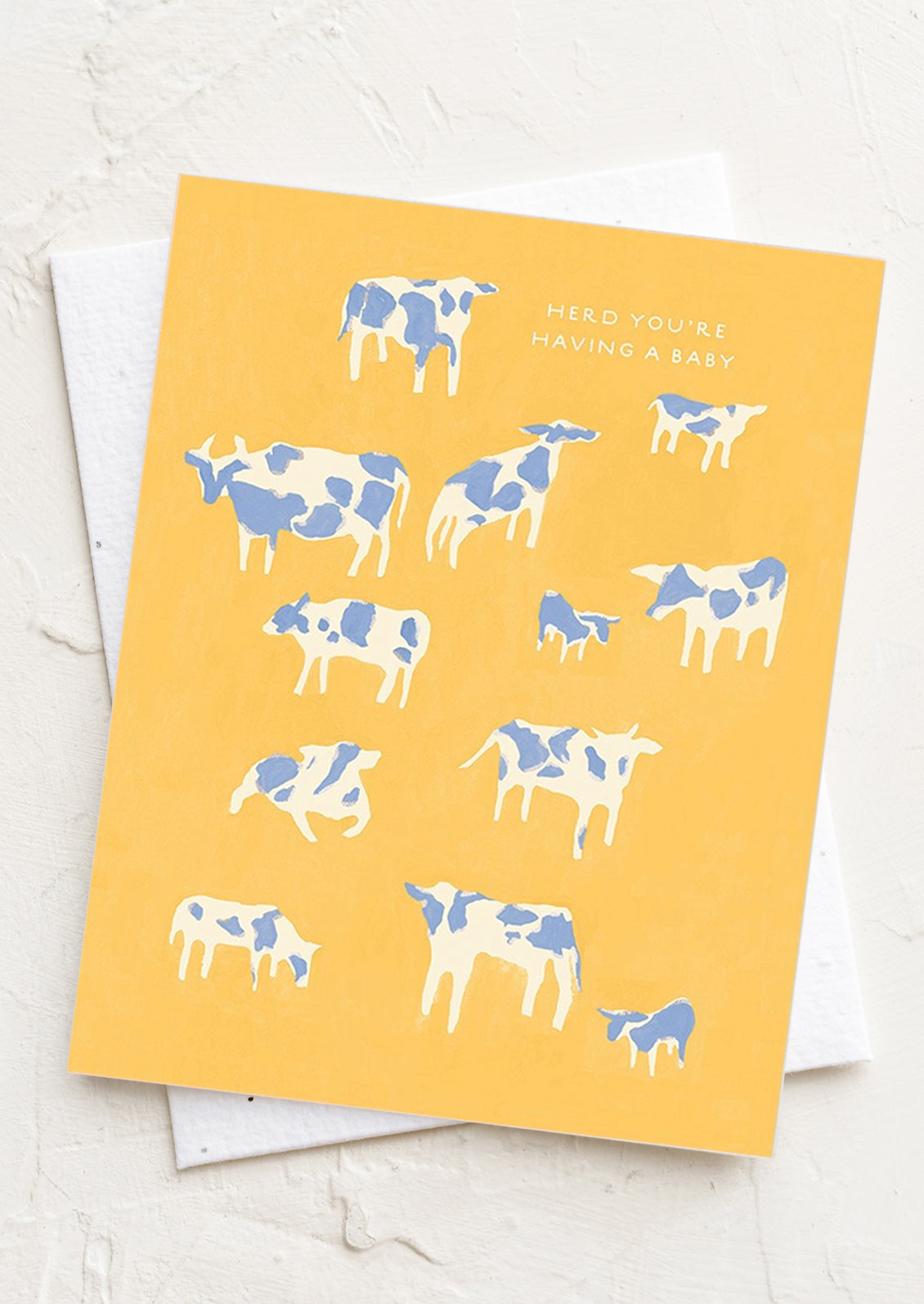 A cow print card reading "Herd you're having a baby".