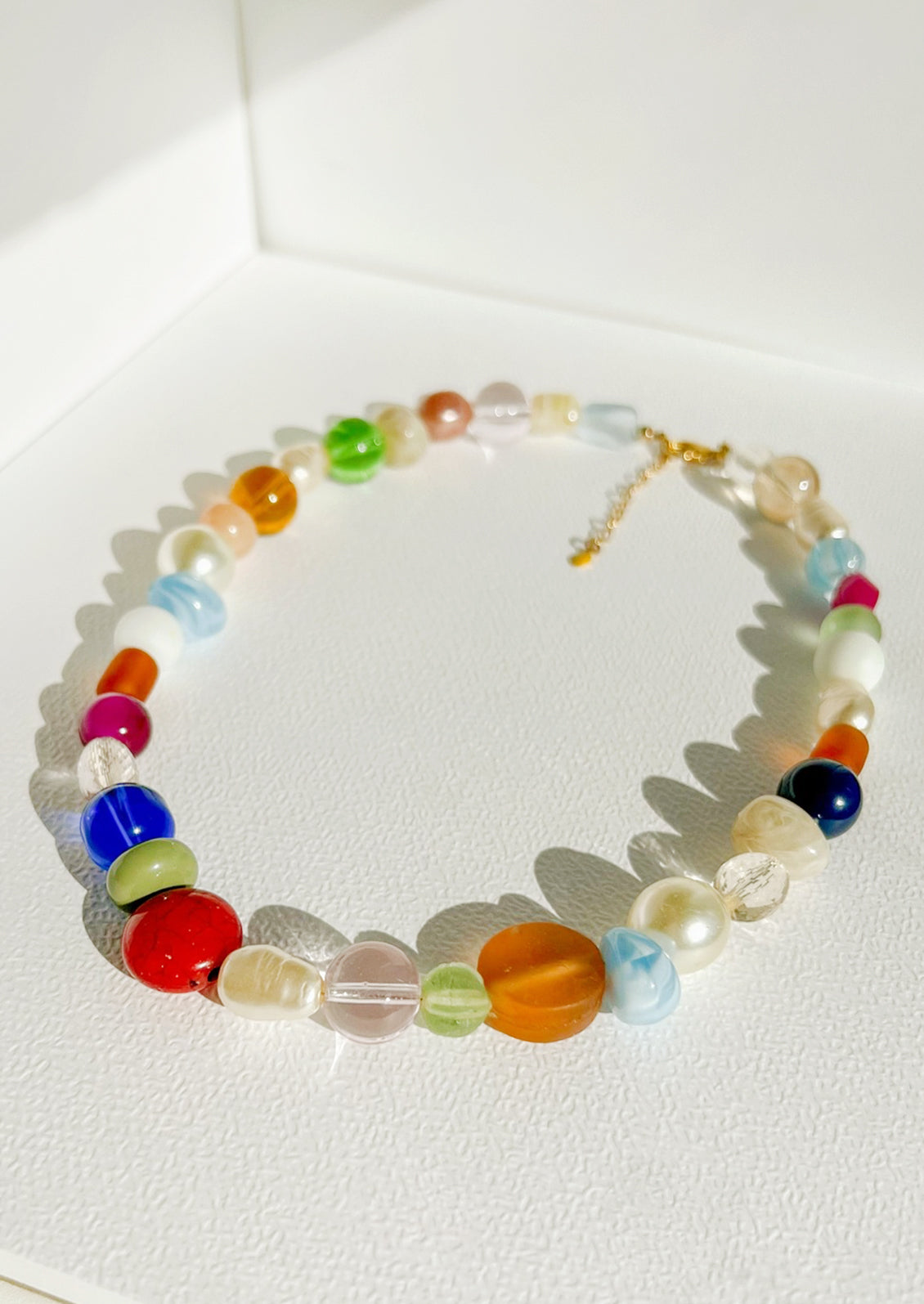 A beaded necklace with wide range of bead types, has a chunky look.