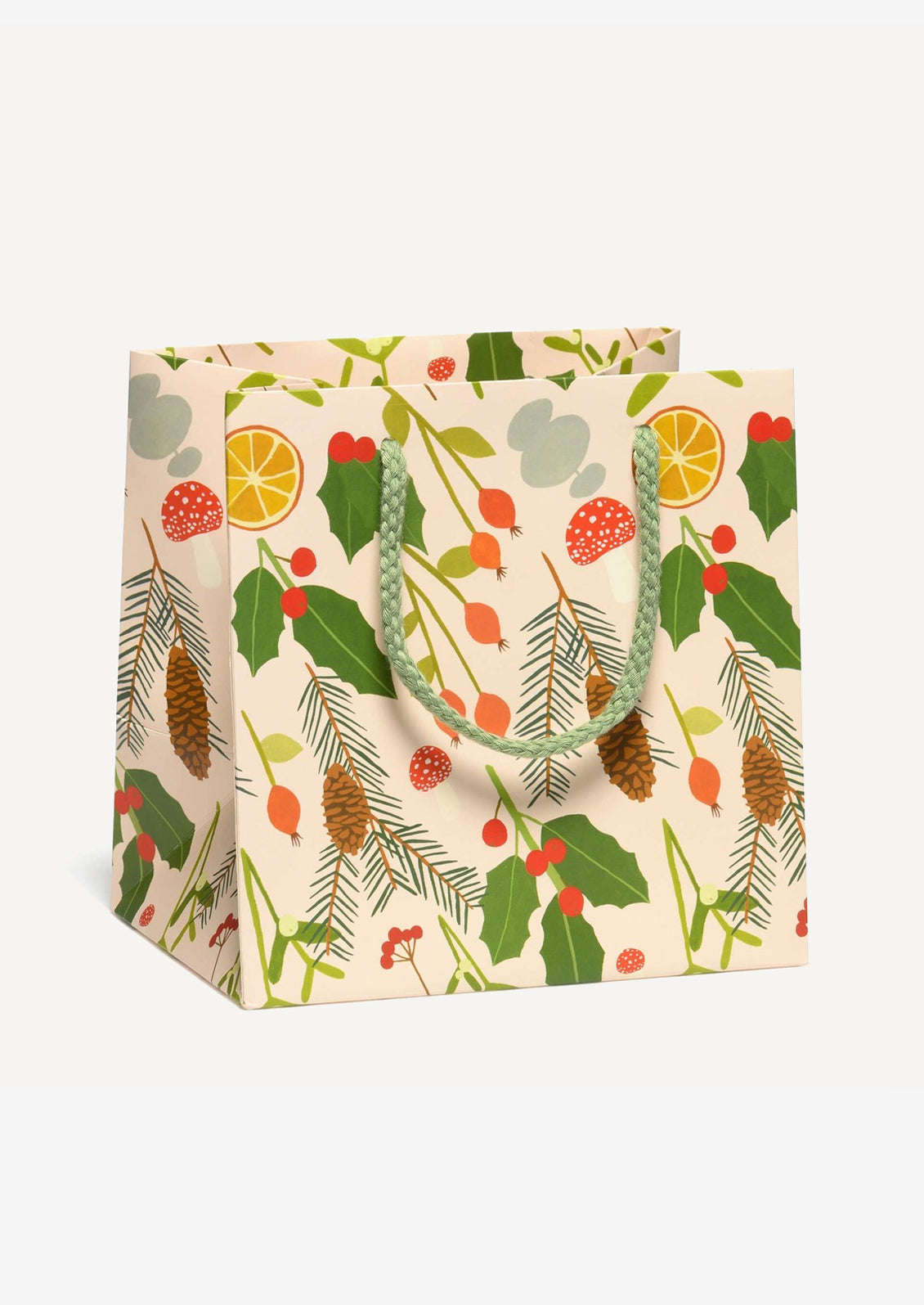 A small printed gift bag in pale cream with festive holly, citrus and pine print.