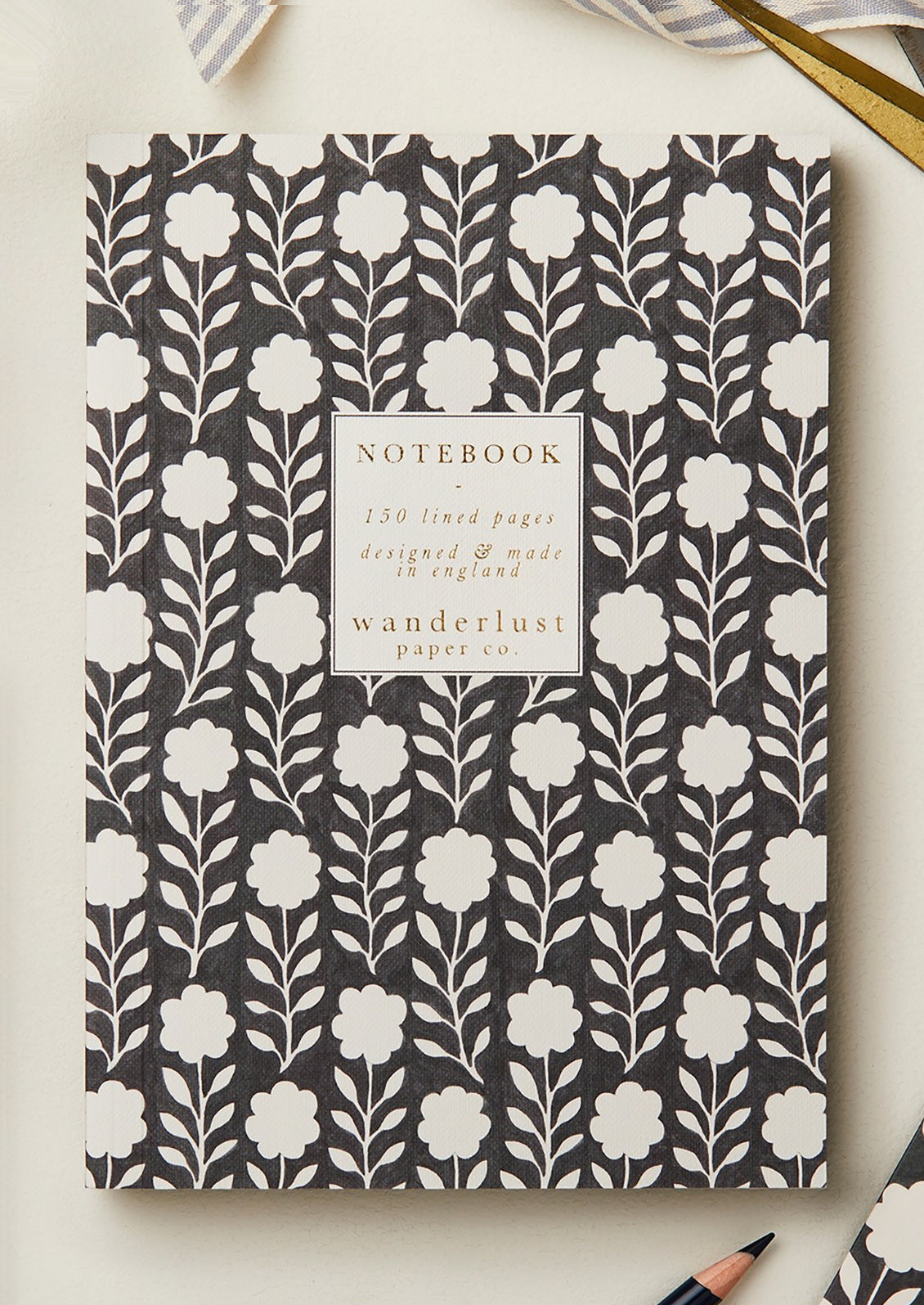 A black and white floral print notebook.