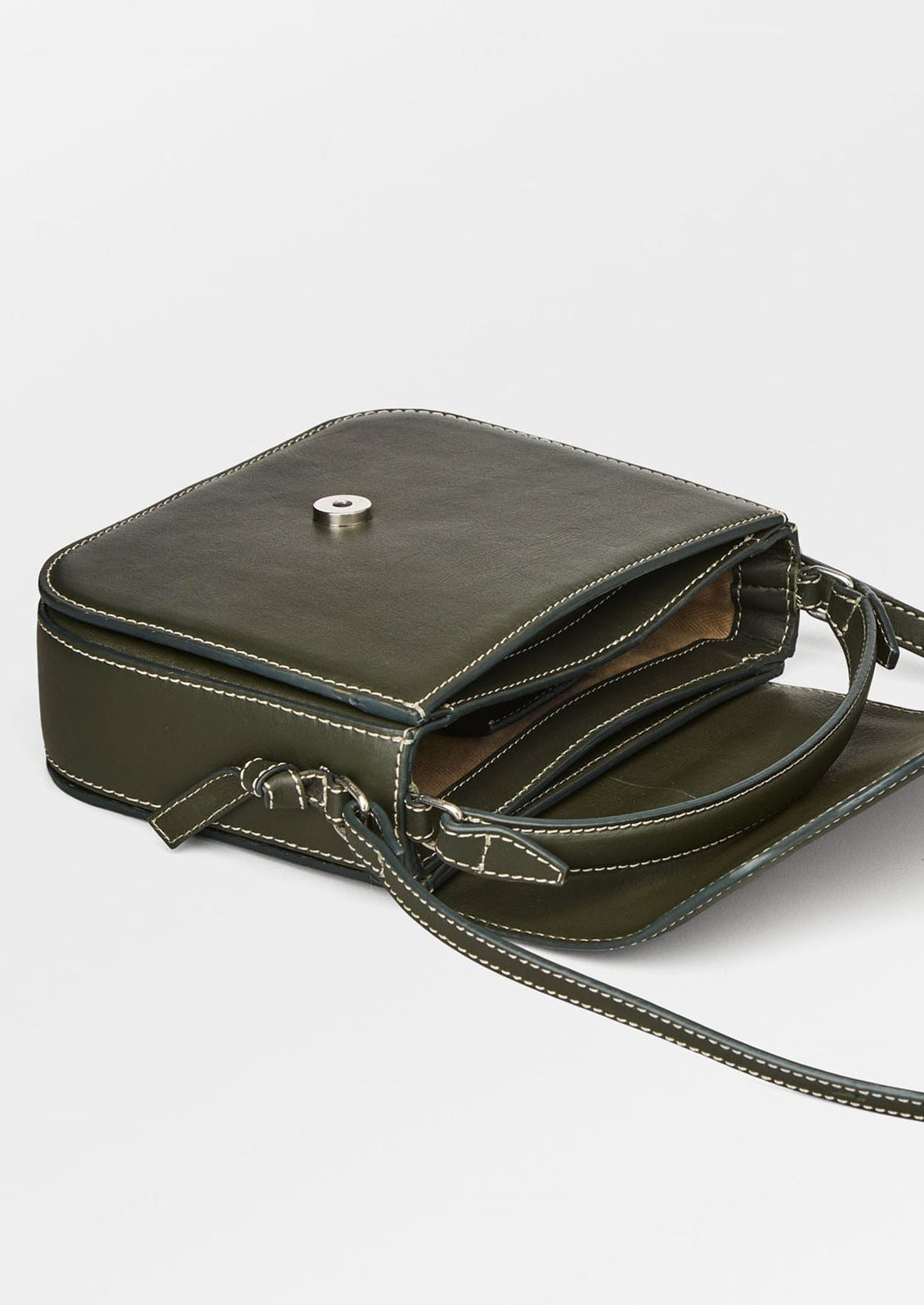 A leather handbag in khaki green with white contrast stitching and flap front design.