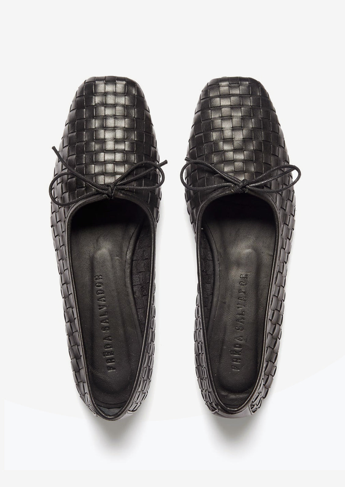 A pair of square toe ballet flats with bow tie in black woven leather.