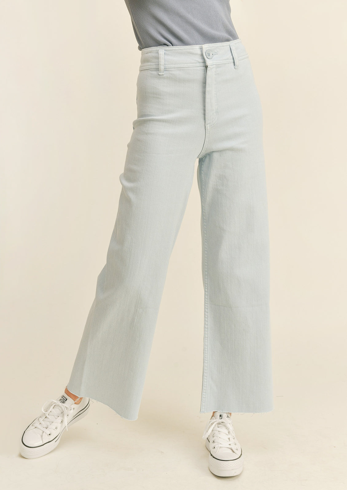 A pair of light powder blue colored wide leg pants with belt loops.
