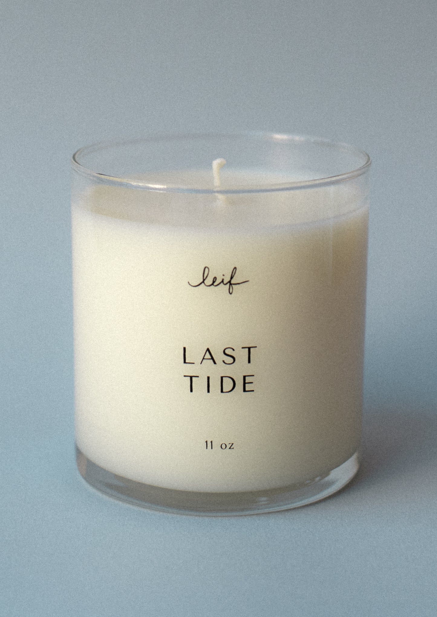 A candle in clear glass jar labeled "Last Tide".