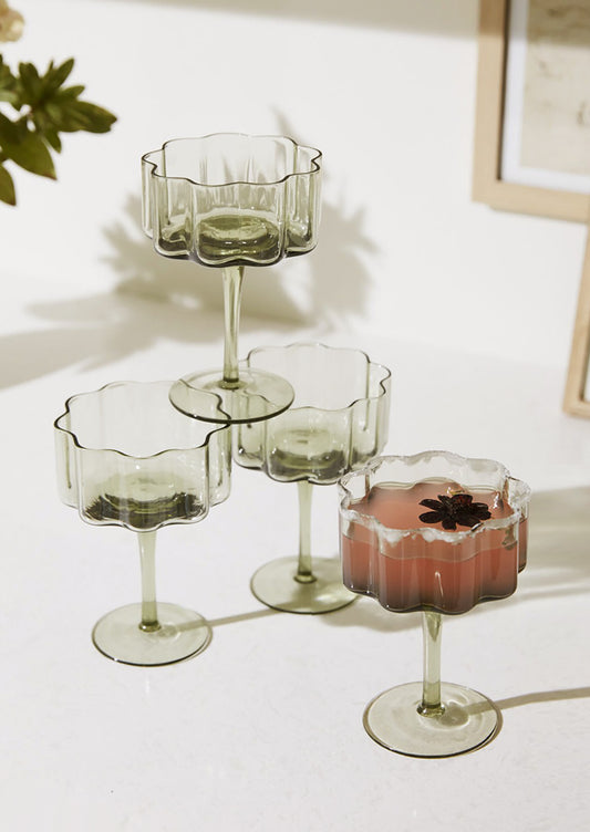 Flower shaped stemmed coupe glasses in natural recycled glass.