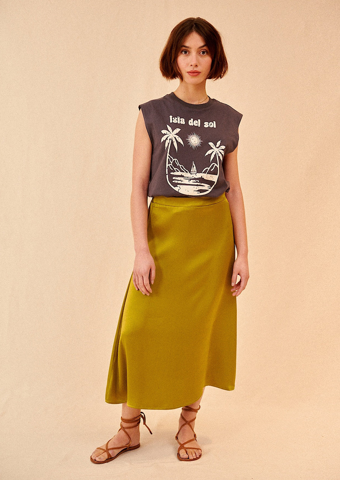 Woman wearing olive green midi skirt, t-shirt, and sandals. 