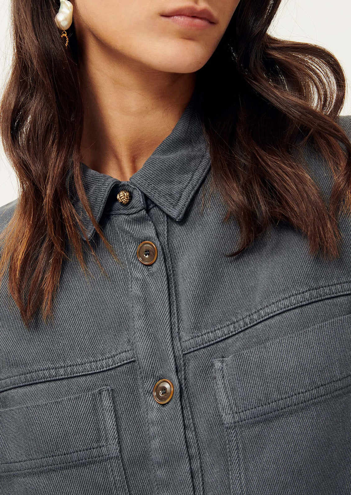 Close-up of woman wearing dark gray shirt jacket. 