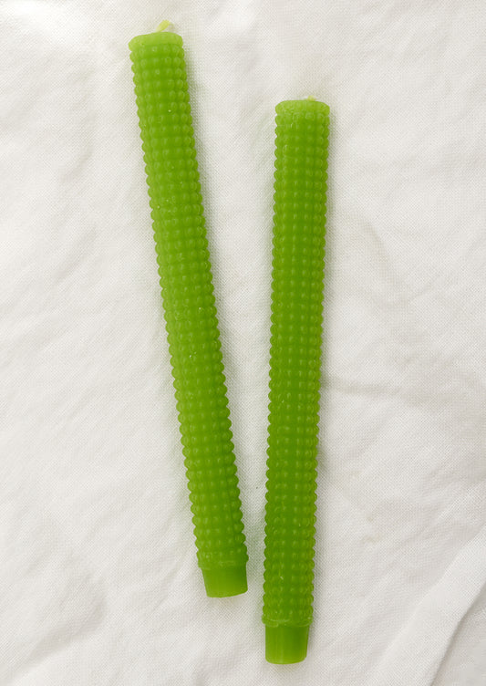 A pair of hobnail textured taper candles in lime green.