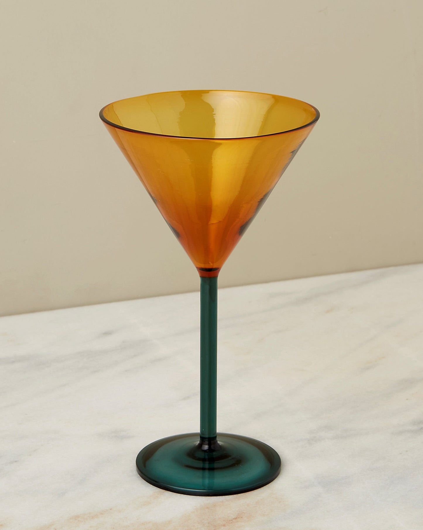 A two tone martini glass with amber upper and teal stem.