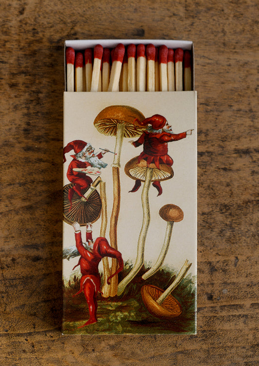 An elf and mushroom printed matchbox with red tipped matches.