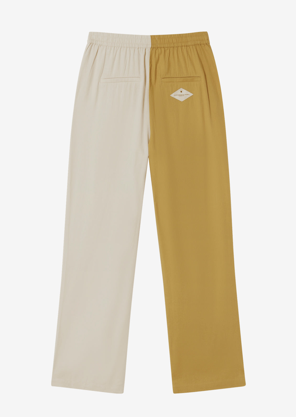 A pair of pants with one leg in yellow and one leg in cream.
