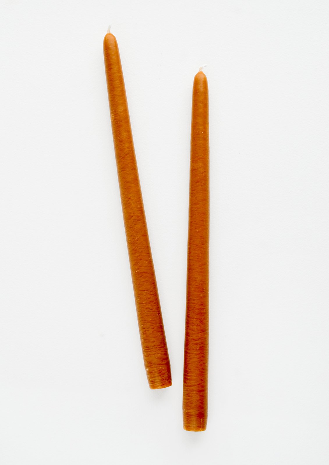 A set of 2 taper candles in the color cinnamon.