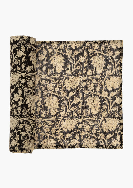 A linen table runner in black with cream block print motif.