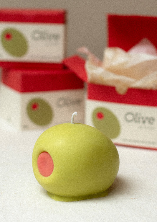 A custom mold candle in shape of red and green olive.