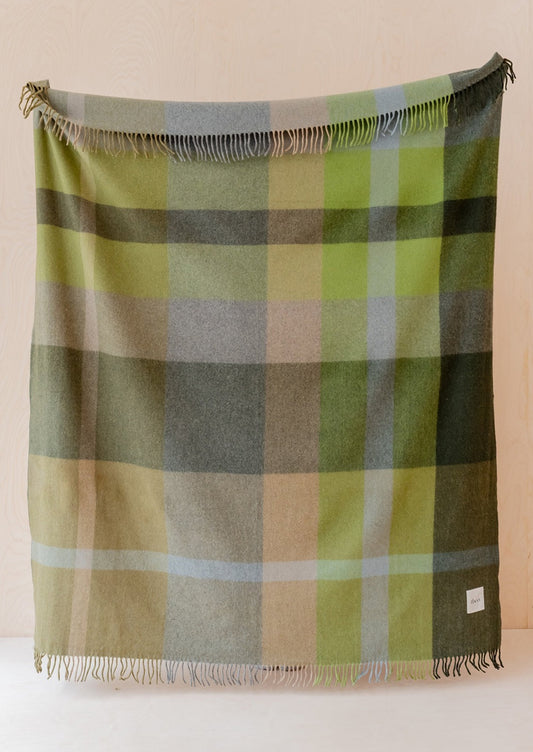 A recycled wool throw in olive green and beige check pattern.