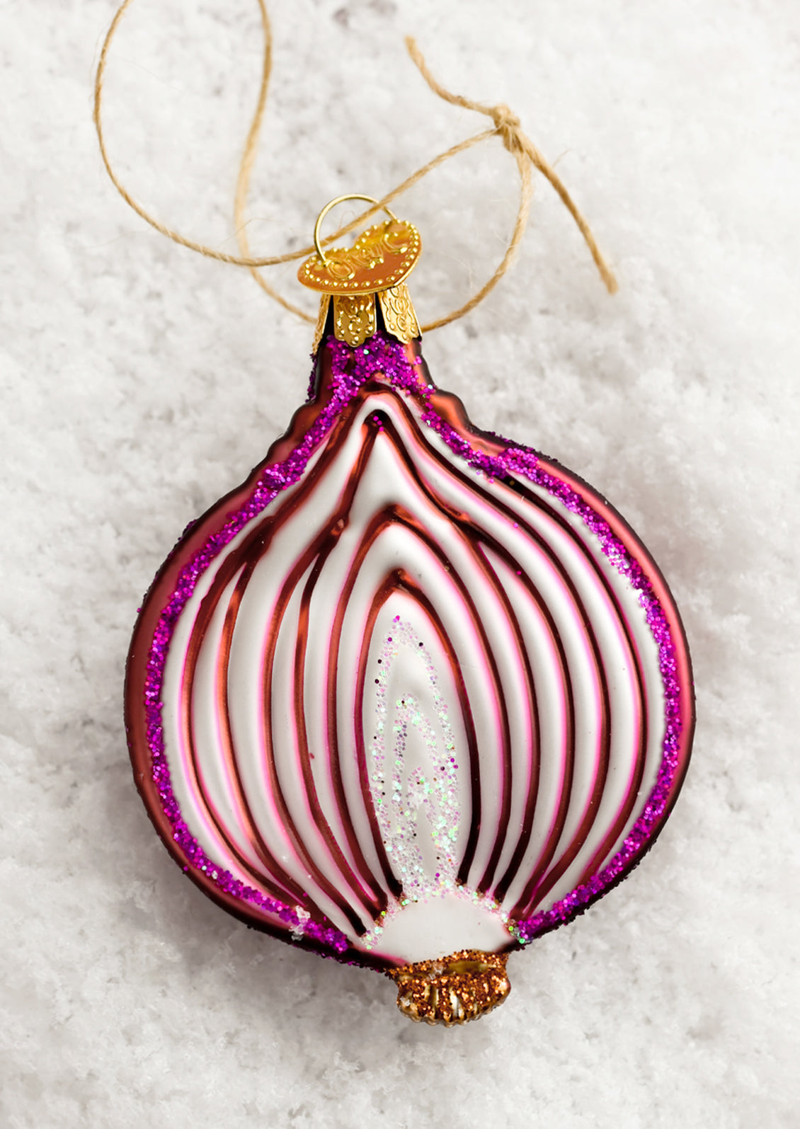 A glass holiday ornament of a sliced red onion.