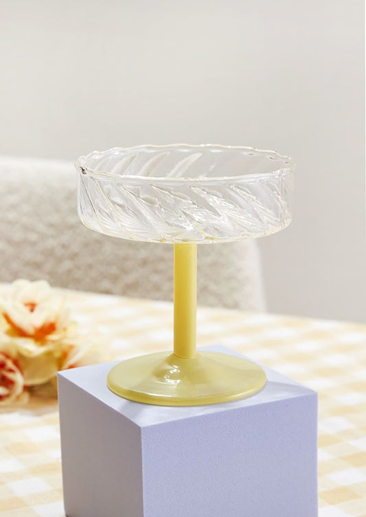 A fluted coupe glass with opaque yellow glass stem.