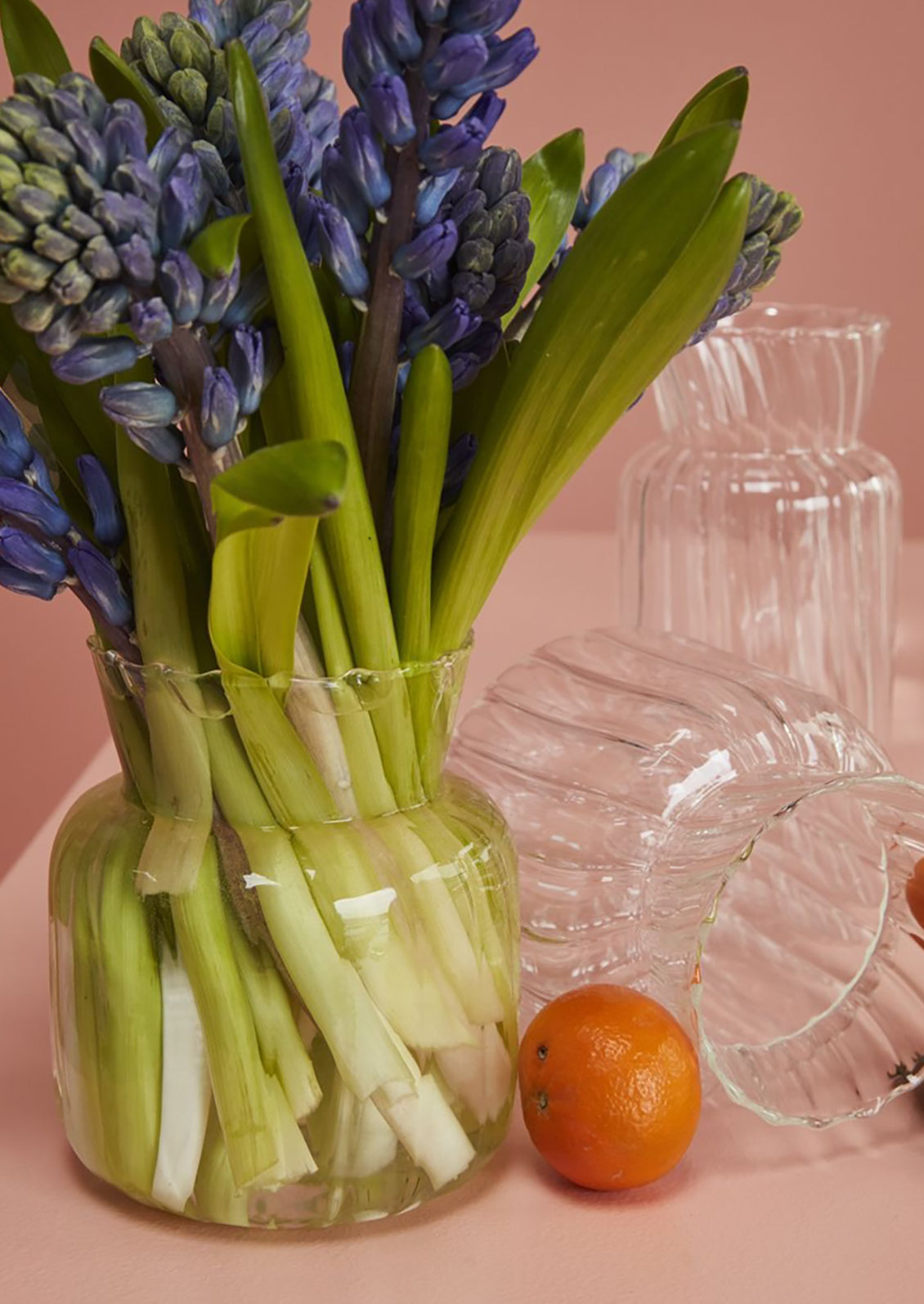 A glass vase with flowers on a table.