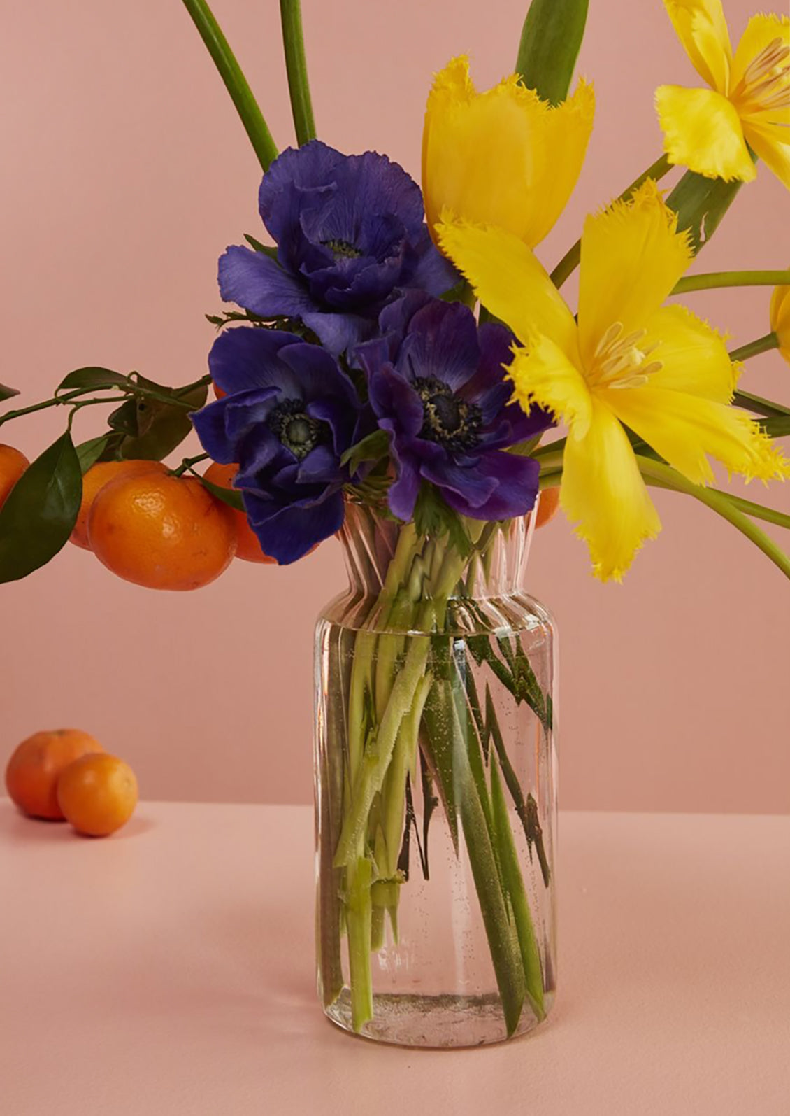 A glass vase with flowers on a table.